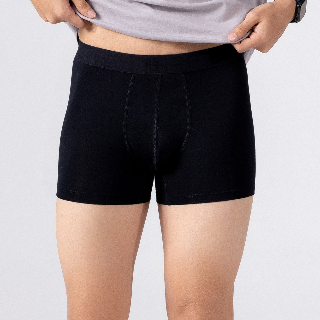 Person is wearing black HIELABS Coolism Trunks paired with a grey t-shirt for everyday comfort.