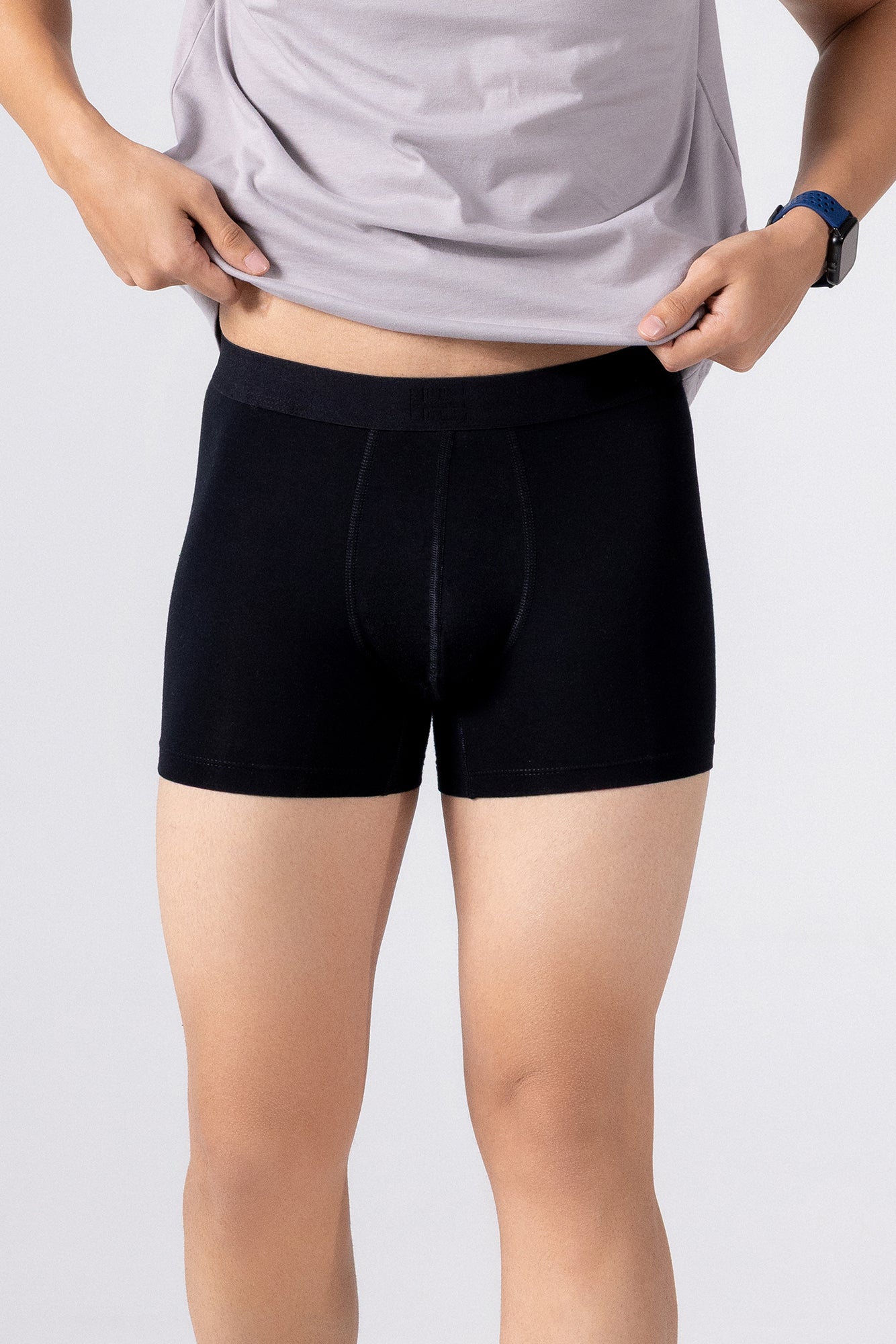 Person is wearing black HIELABS Coolism Trunks paired with a grey t-shirt for everyday comfort.