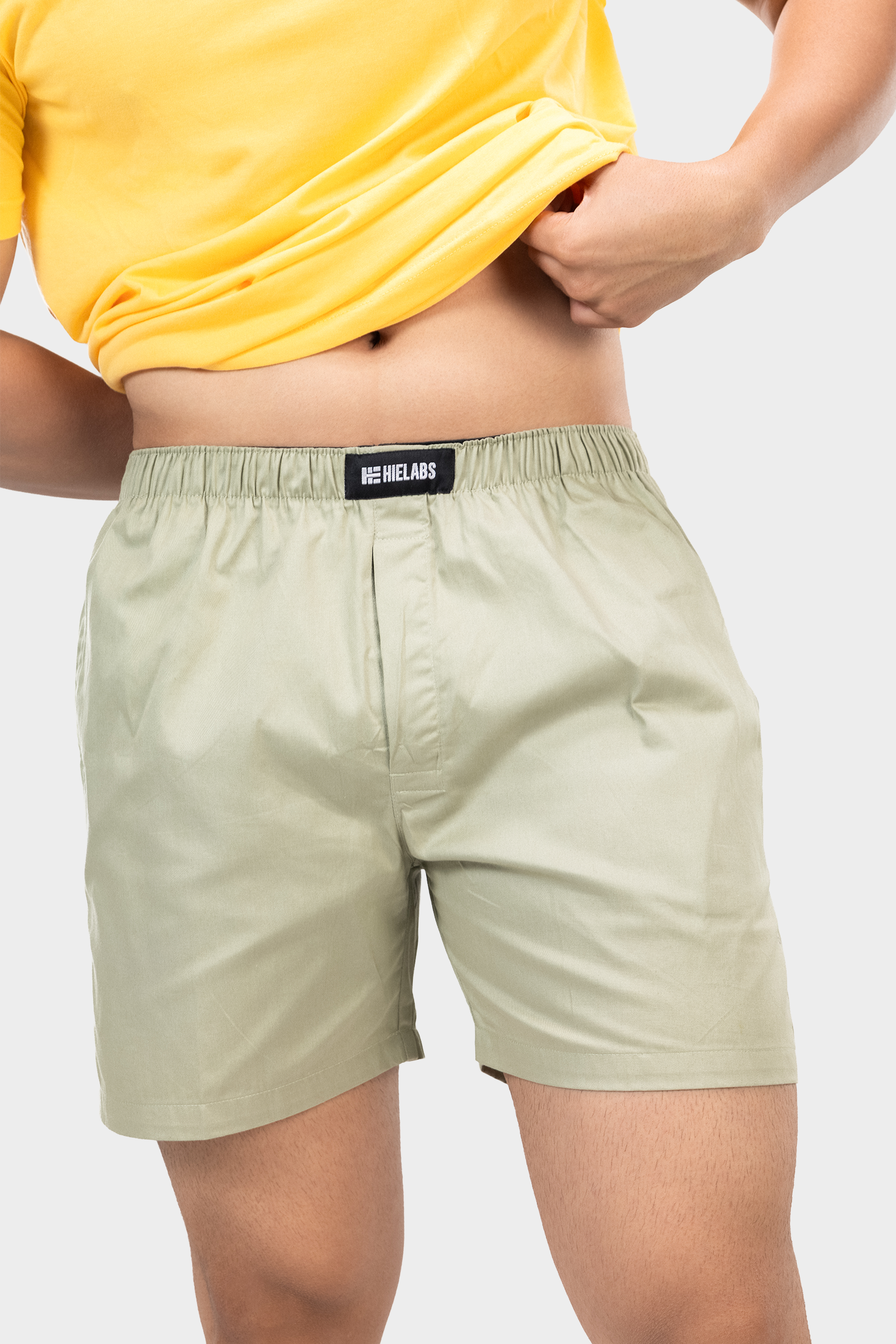 Person wearing a yellow t-shirt and green HIELABS shorts with an elastic waistband.