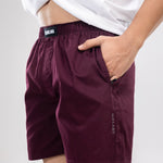 Person wearing a white t-shirt and maroon HIELABS boxers with an elastic waistband, hand in pocket.