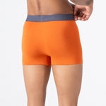 Person wearing orange HIELABS Coolism Trunks featuring breathable stretch fabric and contrast waistband.