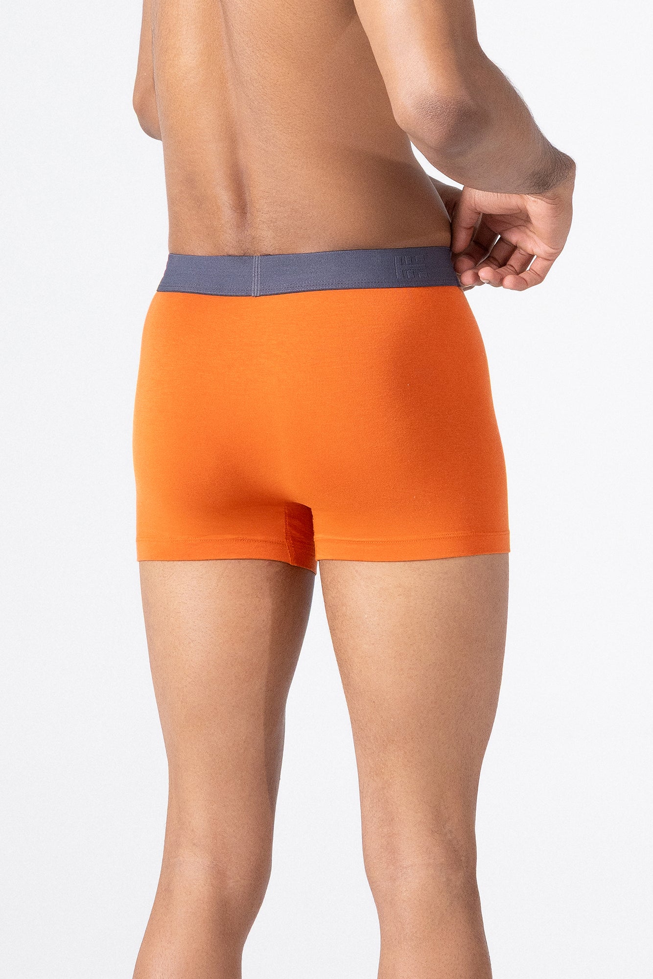 Person wearing orange HIELABS Coolism Trunks featuring breathable stretch fabric and contrast waistband.