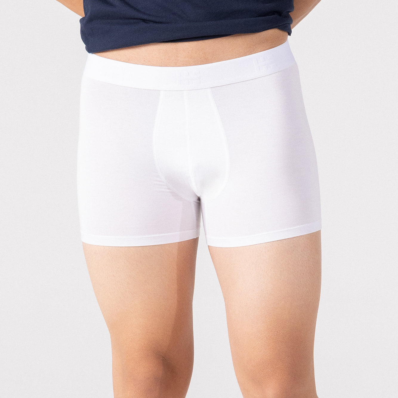 Person wearing a navy blue t-shirt and white HIELABS Coolism Trunks with comfortable elastic waistband.
