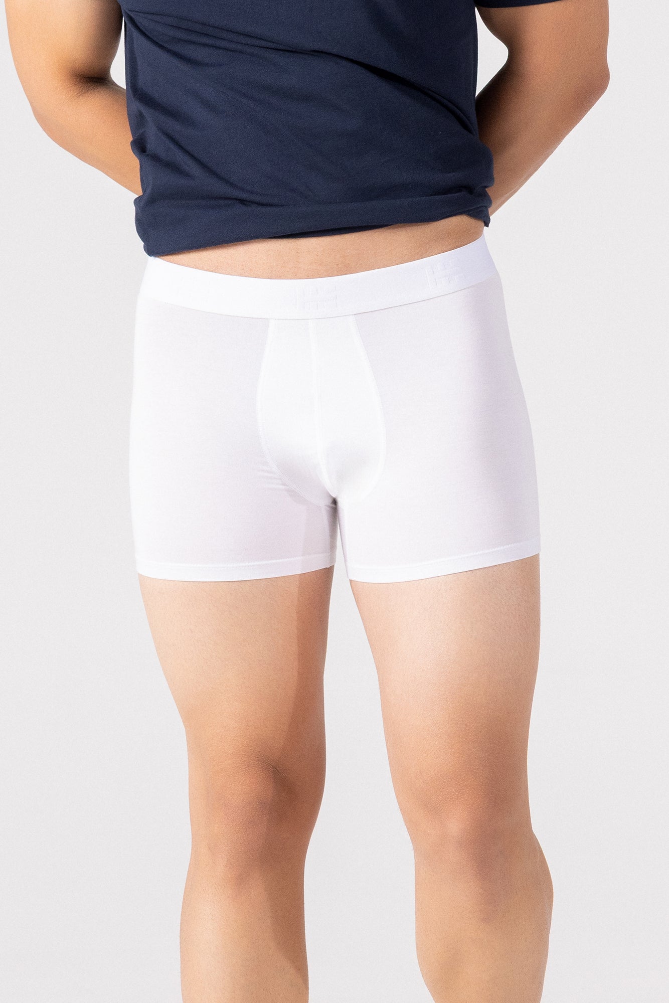 Person wearing a navy blue t-shirt and white HIELABS Coolism Trunks with comfortable elastic waistband.
