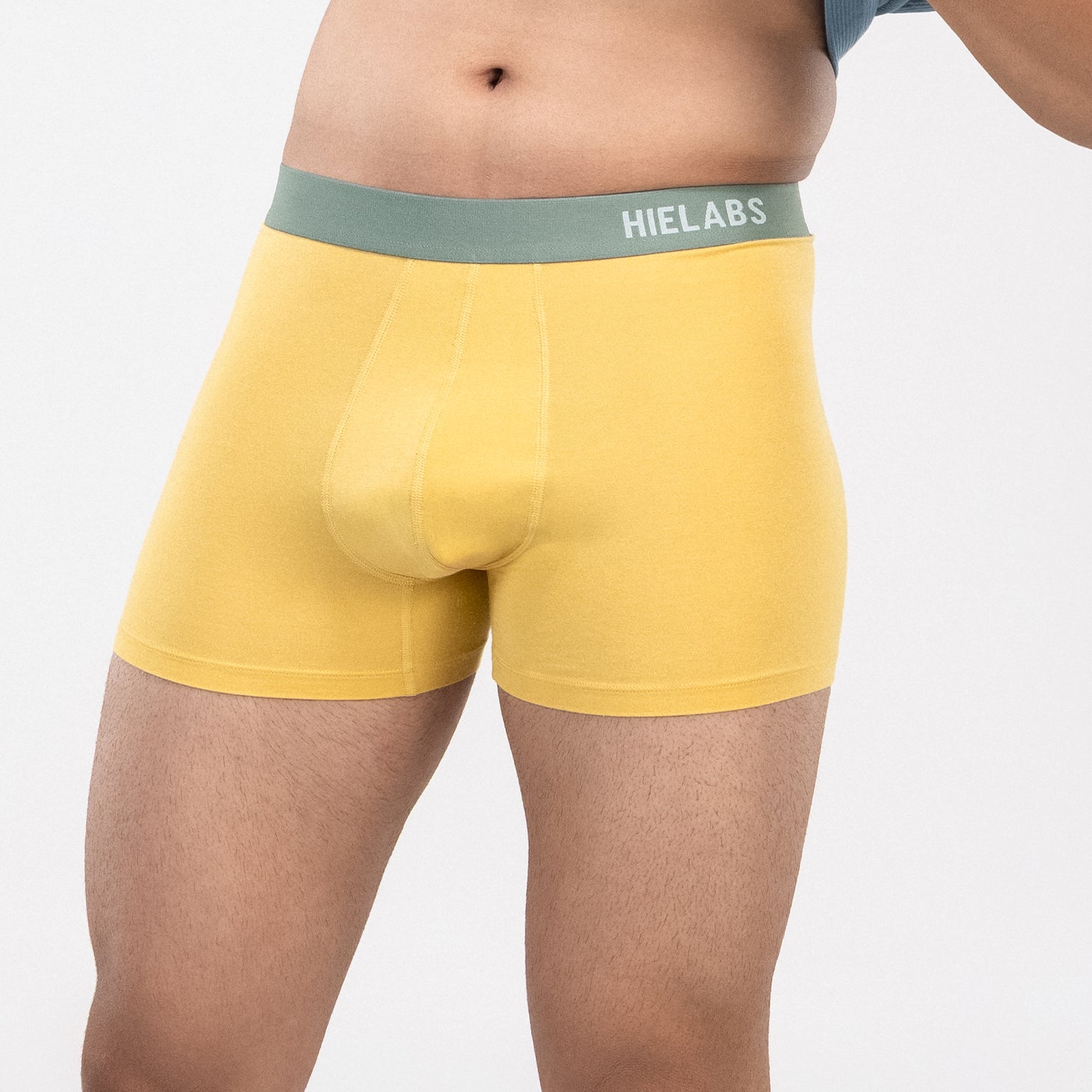 Person is wearing yellow HIELABS Coolism Trunks paired with a blue t-shirt for everyday comfort. 
