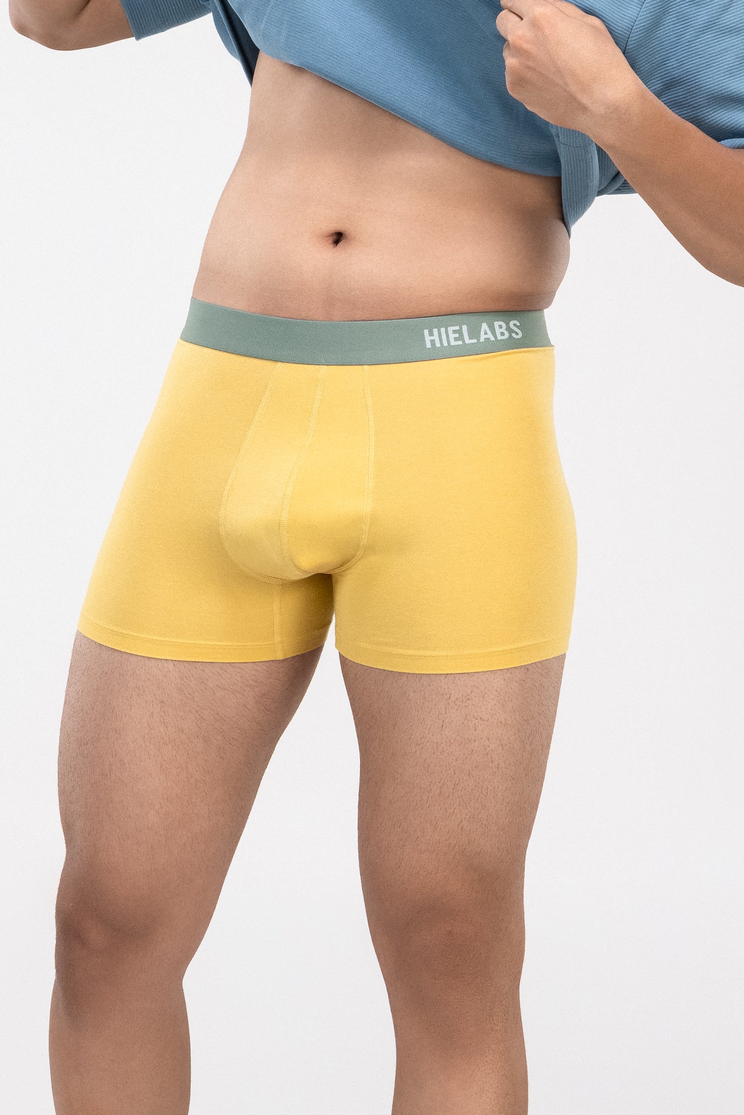 Person is wearing yellow HIELABS Coolism Trunks paired with a blue t-shirt for everyday comfort. 
