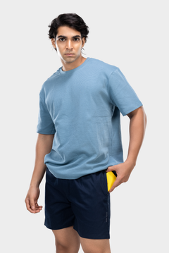 Person wearing a blue t-shirt and dark blue HIELABS boxers with elastic waistband, hand in pocket.