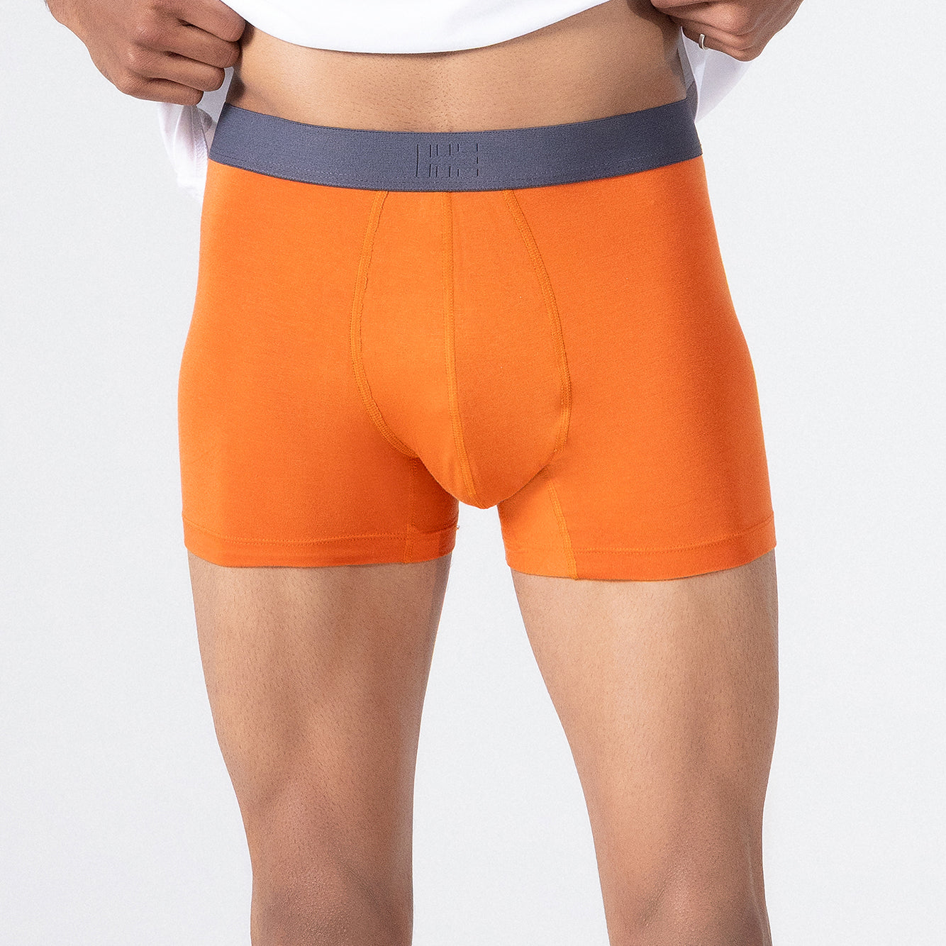 Person wearing a white t-shirt and orange HIELABS Coolism Trunks with comfortable elastic waistband.
